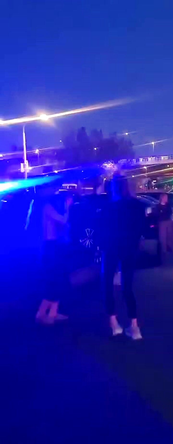Menschen tanzen bei blauem Licht am Rheinufer