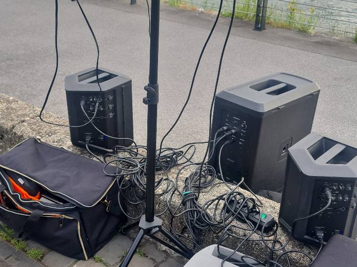 Verkabelte Lautsprecher und Subwoofer beim mobilen Aufbau am Rheinufer
